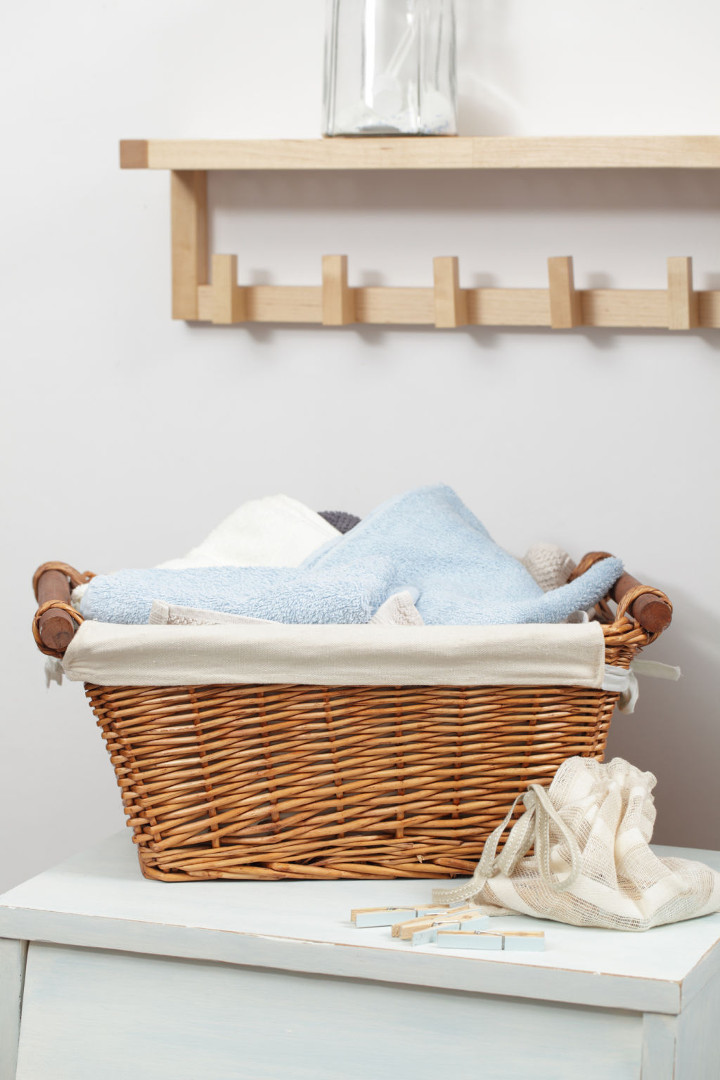 Basket with towels and clothespins in the bag in laundry room